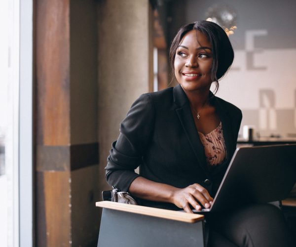 African american business woman working on a computer in a bar